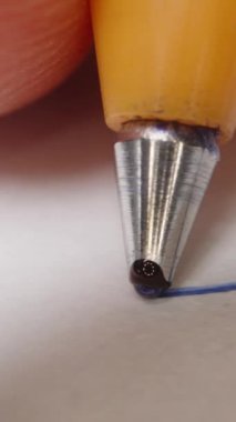 Dikey video. Birinci şahıs görüşü, adam düz bir çizgi çekerken kamera tükenmez kalemi takip ediyor. Dolly kaydırıcı aşırı yakın çekim.