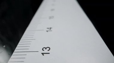 Cetvel boyunca kayar, kamera 15 santimetrede durur ve adam kurşun kalemle iz bırakır..