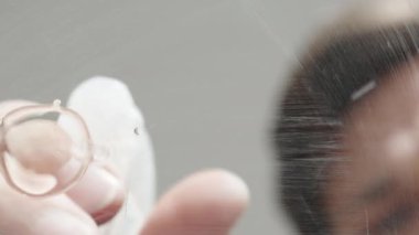 Adam bardağı yıkar, suyu sıçratır ve bir bezle siler, diğer taraftan manzara, makro..