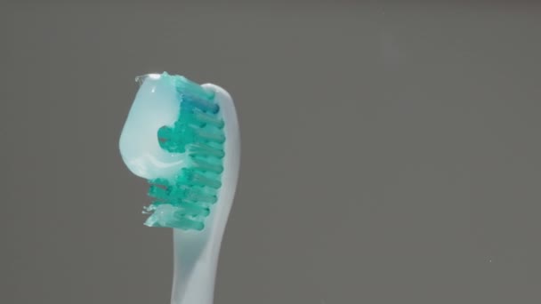 Зубная Щетка Зубной Пастой Вращающаяся Разных Направлениях Концепция Стоматологической Помощи — стоковое видео