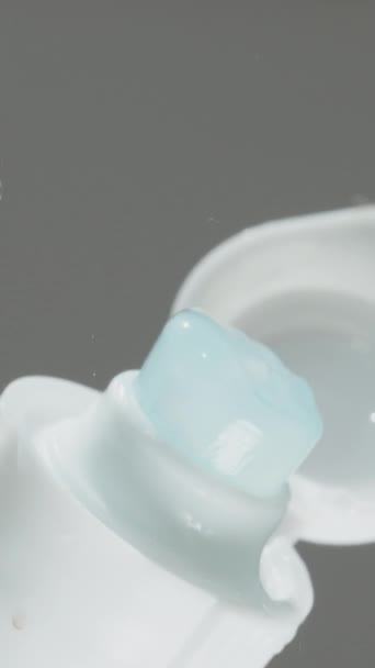 垂直录像 蓝色牙膏 内有美白正方形 底部视图 把它从管子里挤出来 — 图库视频影像