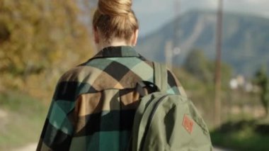 Yeşil Kareli Tişörtlü, Sırt çantalı Genç Bir Kadının Arkasından, Uzun Dağ ve Güneşli Hava Arkasında Tek Başına Yolculuk.
