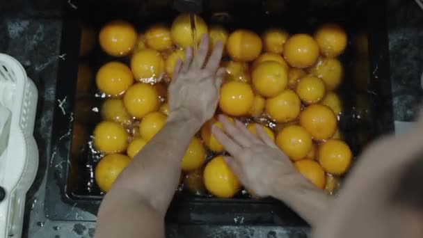 Een Vrouw Wast Sinaasappels Een Zwarte Gootsteen Overlopen Met Fruit — Stockvideo