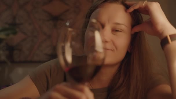 快乐的年轻女人一边喝着红酒一边看着我 温暖的光 餐馆晚餐 — 图库视频影像