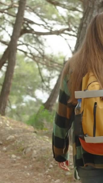 バーティカルビデオ 急なアクセントで森でローリングテレイン 若い女性の登山家は彼女の夢に向かって装備します ジャーニー — ストック動画