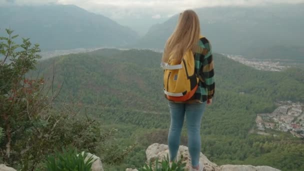 バックパックで軽く旅する無料の若い女性 海の景色を眺めるクリフの端にあるスタンド — ストック動画
