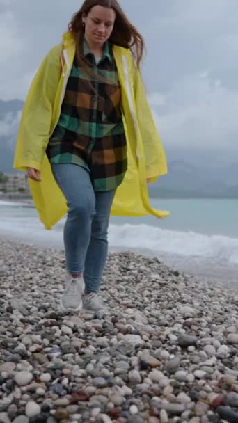 Девушка Жёлтом Плаще Прогуливается Приморскому Пляжу Время Шторма Горами Тёмными — стоковое видео