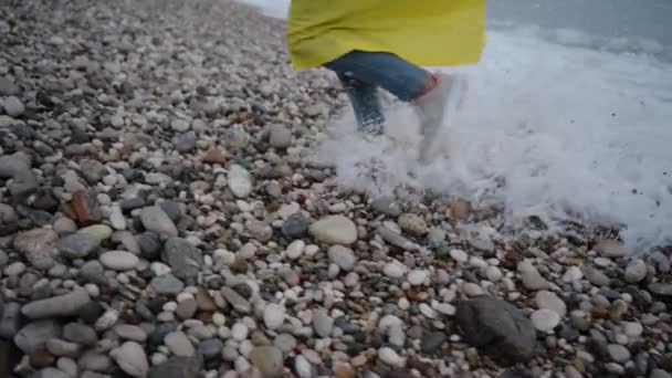 穿着拖鞋和牛仔裤的雌性腿从海浪中跑开 它追上了它们 腿也湿透了 桑迪海滩慢动作 — 图库视频影像