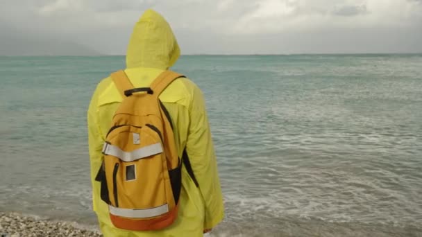 Samotna Osoba Jasnożółtym Płaszczu Przeciwdeszczowym Plecakiem Stoi Patrzy Oddali Tle — Wideo stockowe