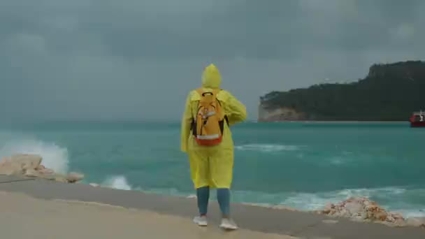 Woman Yellow Raincoat Seaside Promenade Storm Blue Water Waves Crashing — Stock Video