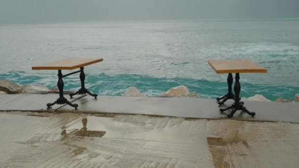 海上的风暴 一个大浪正接近码头边一家餐馆的餐桌 溅落的水花把桌子弄湿了 慢动作 — 图库视频影像