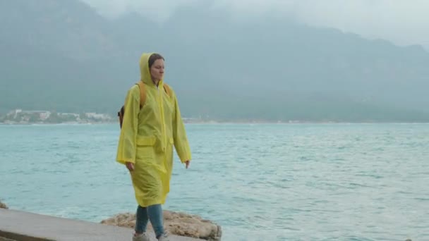 Una Joven Viaja Con Tiempo Lluvioso Vistiendo Impermeable Amarillo Camina — Vídeo de stock