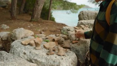 Deniz kenarında antik bir şehrin kazıları. Genç bir kadın kil çömlek parçalarını inceliyor..