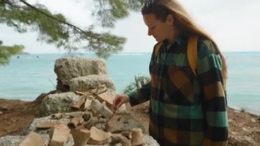 Deniz kıyısındaki Phaselis şehrinin kalıntılarında bulunan antik kil çömlek parçaları. Genç bir kadın onları inceliyor..