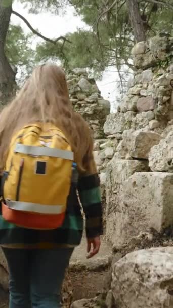 Pionowe Wideo Kobieta Pomarańczowym Plecakiem Spaceruje Zrujnowanych Budynkach Starożytnego Miasta — Wideo stockowe