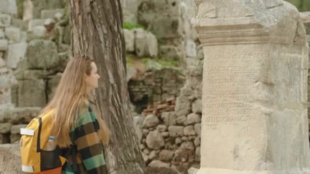 Una Joven Turista Toca Una Vieja Columna Piedra Con Inscripciones — Vídeos de Stock