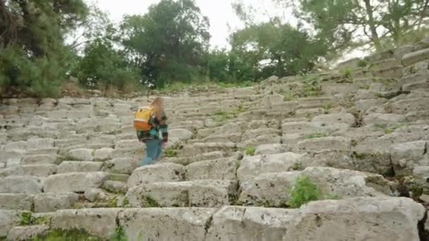 Egy Női Turista Hátizsákkal Felmászik Egy Görög Amfiteátrum Lépcsőjén Ami — Stock videók