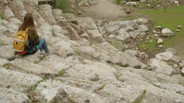 Kobieta Turystka Plecakiem Siedzi Dole Schodach Starożytnego Greckiego Amfiteatru — Wideo stockowe