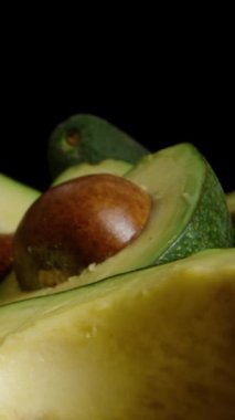 Kamera, dilimlenmiş avokado yarımları boyunca ilerler, çukura gittikçe daha da yaklaşır, makro detaylarını yakalar..