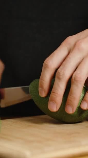 Auf Einem Holztisch Liegen Avocadofrüchte Eines Wird Von Einem Mann — Stockvideo