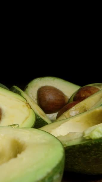 Sliced Avocado Μισά Avocado Pits Είναι Τοποθετημένα Στο Τραπέζι Μαύρο — Αρχείο Βίντεο