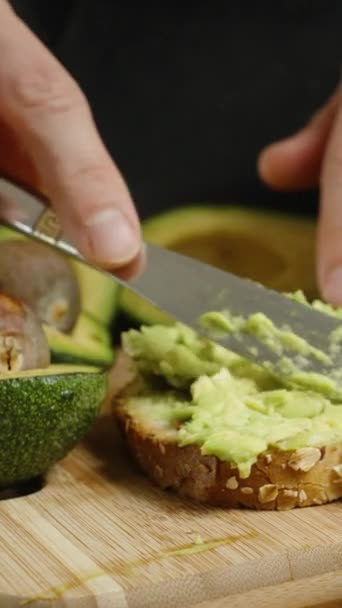 Man Förbereder Hälsosam Frukost Rostat Bröd Med Avokado Kött Puré — Stockvideo