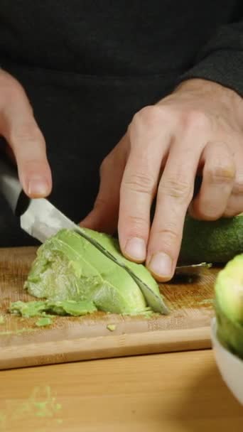 Man Snijdt Avocado Helften Partjes Een Hele Plaat Geschilde Avocado — Stockvideo
