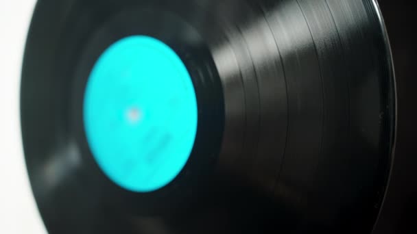 带有蓝色标签的乙烯基唱片 在黑白背景下旋转 有选择性地聚焦 — 图库视频影像