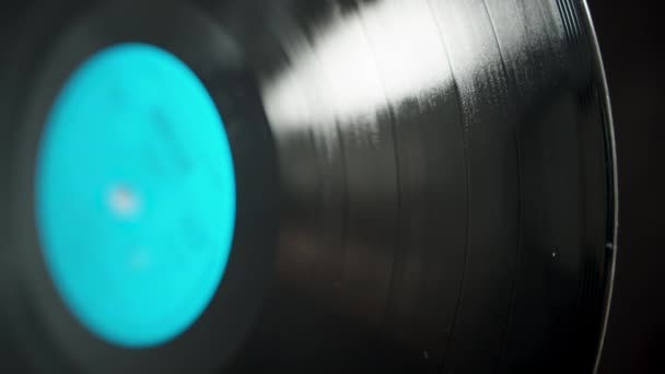 带有蓝色标签的Vinyl音乐唱片 黑色背景旋转 表面反射光 — 图库视频影像