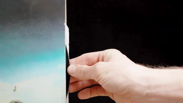 一个男人从蓝色袖子里拿出一张乙烯唱片 在黑色背景上拍了一张滑块 — 图库视频影像
