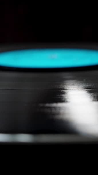 在黑色背景上的乙烯基唱片的分散慢动作旋转 蓝色标签 — 图库视频影像