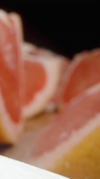 Vertikální Video Kusy Krájeného Grapefruitu Posypané Cukrem Prkně Černém Pozadí — Stock video