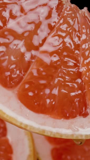 垂直录像 在一半柚子的背景下 挂着一片叶子 果汁从上面滴下 — 图库视频影像