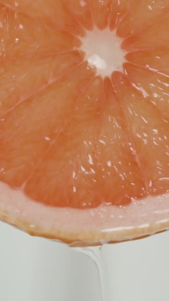 Saft Fließt Eine Scheibe Roter Grapefruit Auf Weißem Hintergrund Herunter — Stockvideo