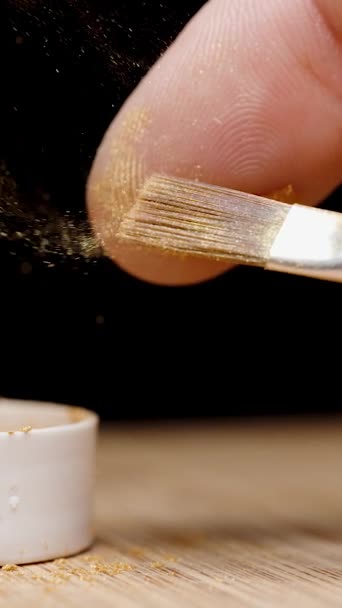 Ein Finger Läuft Mit Goldpuder Über Den Pinsel Und Partikel — Stockvideo