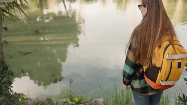 Tourist Woman Backpack Observes Fish Pond She Turns Back Indicates — Stock Video