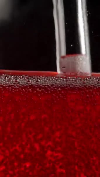 垂直录像 泡泡在一个玻璃瓶与红色苏打水 论黑人背景 — 图库视频影像
