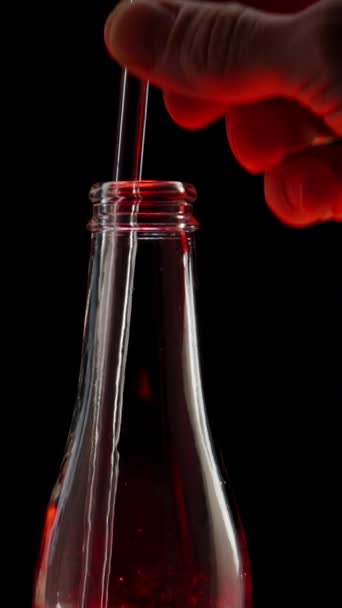 Vertical Video Man Inserts Straw Bottle Red Light Darkness Drinks — Stock Video