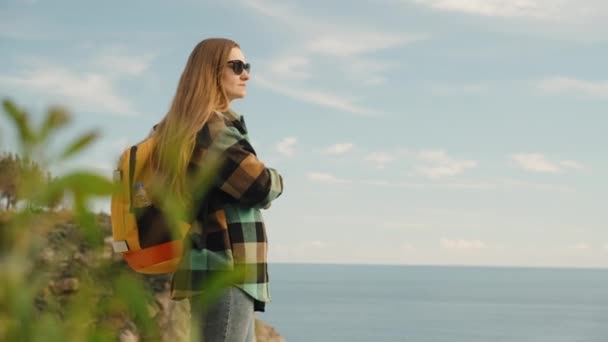 Ensam Kvinnlig Resenär Med Ryggsäck Blickar Avståndet Från Hög Klippa — Stockvideo
