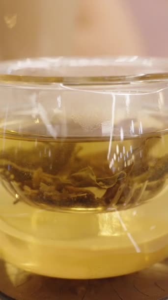 バーティカルビデオ お茶のカップでは テーブルの上の甘いデザートの背景に対して砂糖が注がれています スローモーション — ストック動画