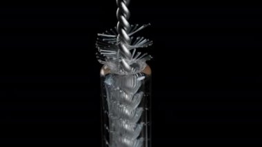Temizlik fırçası cam tüpten çıkıyor ve plastik kıllarını açıyor. Makro çekim.