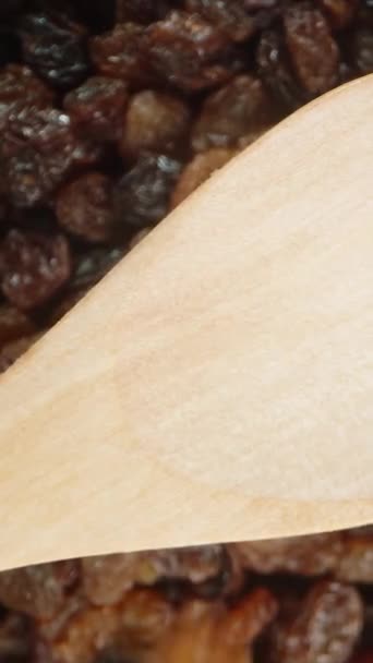 垂直录像 从上面 葡萄干倒在一个木制勺子上 背后有许多葡萄干 慢动作 — 图库视频影像