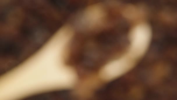 摄像机慢慢地聚焦在木制勺子里的葡萄干上 葡萄干背景的特写 — 图库视频影像