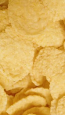 Dikey video. Besleyici bir kahvaltı için altın mısır gevreğinin arka planı. Üst Manzara. Dolly kaydırıcı, kapat..