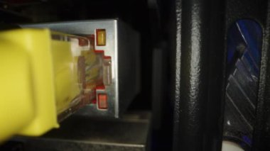 Bir bilgisayarın internet bağlantısı, yanıp sönen ışıkları ve sarı kablosu olan ethernet portu. Dolly kaydırıcı aşırı yakın çekim.