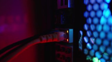 Masaüstü bilgisayarının arkasındaki ethernet portu, internet bağlantı portundaki ışıklar yanıp sönüyor, pervanelerden gelen RGB ışıkları karanlıkta renk değiştiriyor.