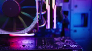 Elektronik bileşenler ve ısıtıcılar üzerinde gökkuşağı RGB ışıklandırması olan bir oyun bilgisayarının ana kartı. Dolly kaydırıcı, kapat..