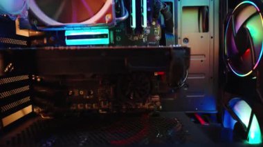 RGB ışıklandırmalı bir masaüstü bilgisayarının içinde, gökkuşağı renkli ışıkları olan sayısız hayran, kamera eğimi. Teknik arkaplan.