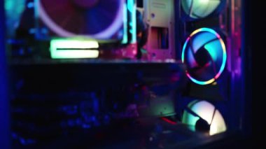 Bir oyun bilgisayarının içinde, RGB aydınlatması, sayısız renkli hayran ve karanlıkta elektronik parçalar..