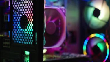 Teknolojik sıçrama ekranı için arka plan, gökkuşağı ışıklandırmalı bir oyun bilgisayarının elektronik parçaları. Çerçeve boyunca yavaş odaklanma tekniği.